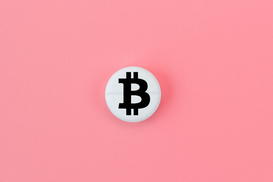 Medical pill with a bitcoin sign on a pink background. Bitcoin technology concept in medicine
