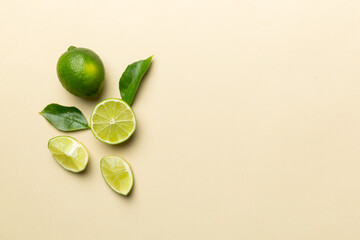 Lime fruits with green leaf and cut in half slice isolated on white background. Top view. Flat lay with copy space