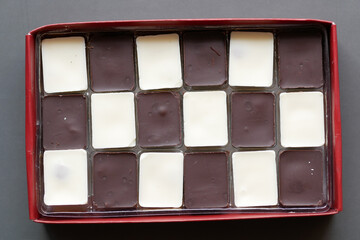 dark and white chocolate in a box on gray background 
