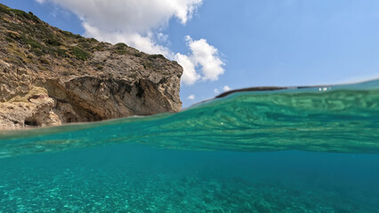 Fototapeta na wymiar Underwater split photo of natural exotic island rocky bay with turquoise crystal clear sea and small caves