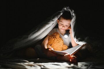 Child reading book in bed. Kids read at night. Little boy with fairy tale books in bedroom ....