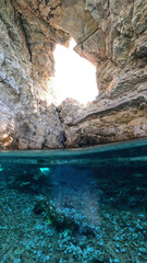 Fototapeta premium Underwater split photo of beautiful paradise pebble rocky bay of Kaladi with turquoise crystal clear sea and small caves, Kythira island, Ionian, Greece