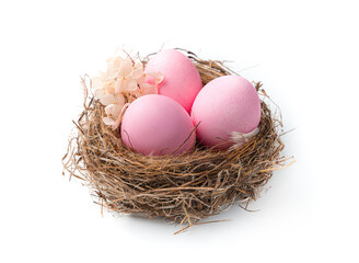 Easter pink eggs in a nest decorated with flowers on a white background.