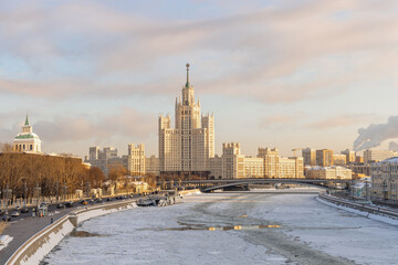 Fototapeta na wymiar The building on Kotelnicheskaya Embankment and the frozen Moskva River in the foreground. Residential skyscraper near the Moscow Kremlin, winter shot. Tourist attraction of Russia in winter
