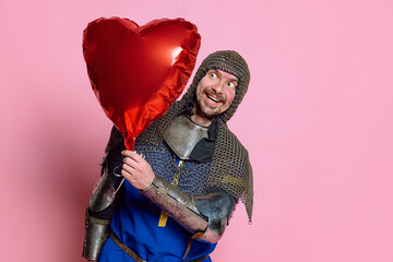 Half-length portrait of happy and excited man, medieval warrior in protective covering with red...