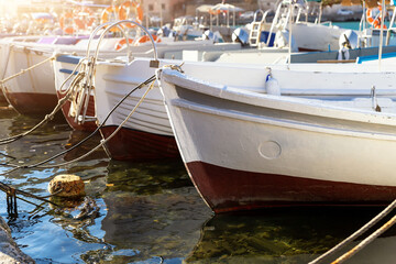 Row of many small old wooden vintage colorful bright fishing ships moored at fisherman village...