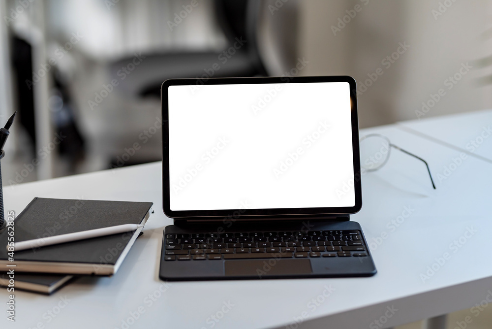 Poster tablet with keyboard blank white screen of placed on office table. mock up.