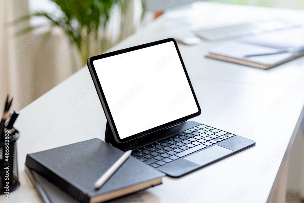 Poster tablet with keyboard blank white screen of placed on office table. mock up.