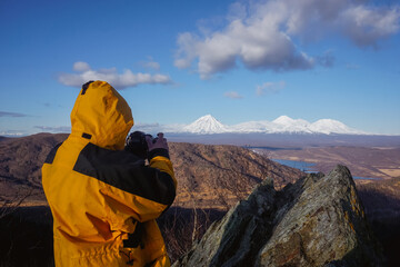 Fototapeta na wymiar The guy takes pictures of volcanoes in Kamchatka