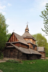 Fototapeta na wymiar An old wooden church in Ukraine. Rural landscape with a church. Wooden Ukrainian church. The green landscape of the countryside. Kiev. Ukraine.