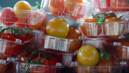 Factory cherry tomatoes packs with fresh organic natural red vegetables closeup