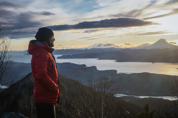 A guy on a mountain overlooking Avacha Bay at sunset