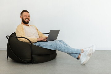 Successful Freelancer Man Using Laptop Working Sitting In Chair Indoors