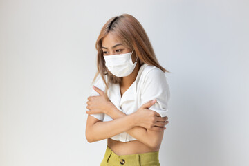 Sick young woman with face mask having fever, chills and body muscle ache