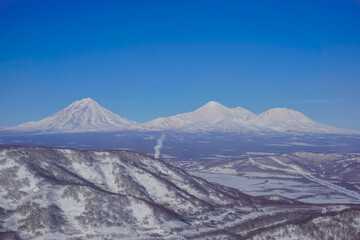 Fototapeta premium Snow covered volcanoes of Kamchatka