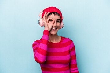 Young caucasian woman listening to music isolated on background excited keeping ok gesture on eye.