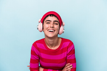 Young caucasian woman listening to music isolated on background laughing and having fun.