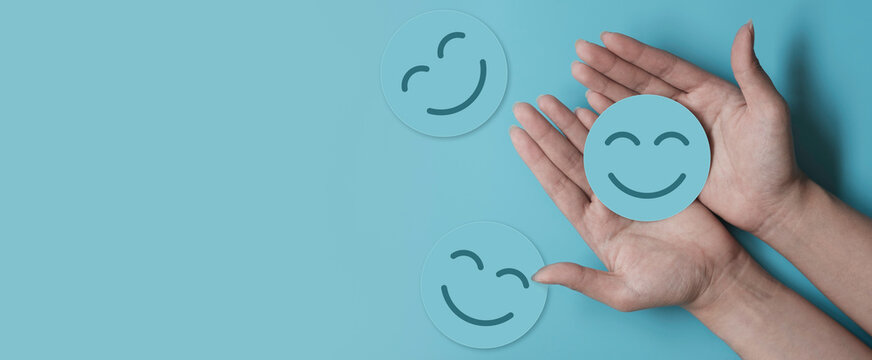 Hand holding blue paper cut happy smile face, positive thinking, mental health assessment , world mental health day concept	