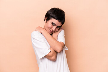 Fototapeta premium Young caucasian woman isolated on beige background hugs, smiling carefree and happy.