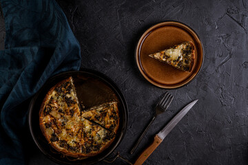 Homemade vegetable pie on dark background. Rustic food photography. Low key image. Top view with copy space.