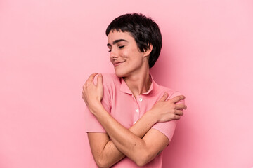 Young caucasian woman isolated on pink background hugs, smiling carefree and happy.