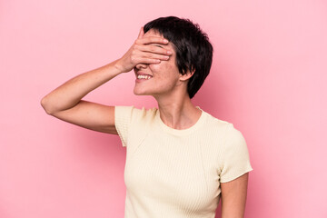 Young caucasian woman isolated on pink background covers eyes with hands, smiles broadly waiting for a surprise.