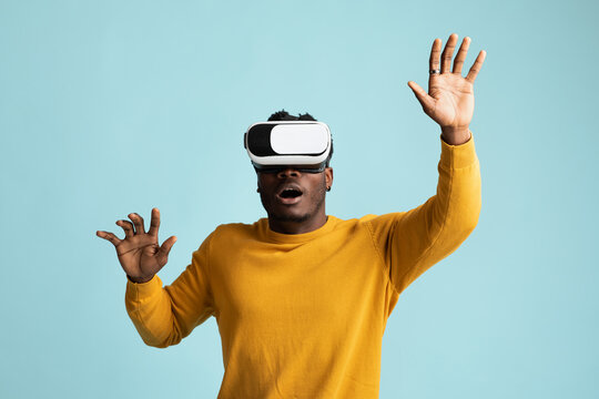 Emotional young african american man using VR glasses