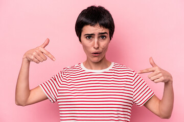 Young caucasian woman isolated on pink background points down with fingers, positive feeling.