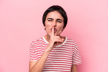 Young caucasian woman isolated on pink background keeping a secret or asking for silence.