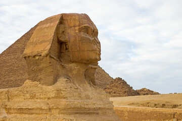 Fototapeta na wymiar Closeup photo of Sphinx, ancient Egyptian limestone statue of a mythical creature with a lion's body and a human's head. Sculpture located on the Giza Plateau, the Pyramid Complex near Cairo, Egypt