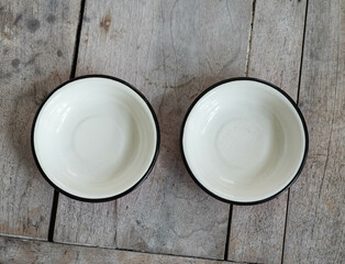 A pair of vintage enameled metal bowl on wooden table from above