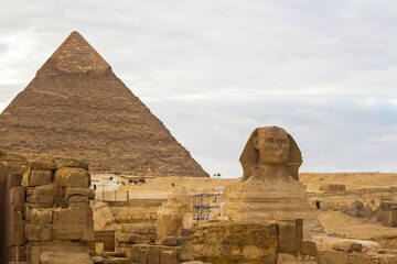 Sphinx and The Great Pyramid of Chephren (also known as Pyramid of Khafre ) on the background. It is the second-tallest and second-largest of the Ancient Egyptian Pyramids of Giza, Cairo, Egypt. 