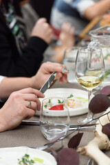 Man eats a dish of fish balls in a creamy sauce served on a table in a restaurant