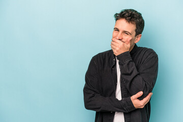 Young caucasian man isolated on blue background laughing happy, carefree, natural emotion.