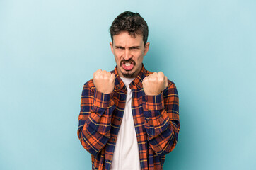 Fototapeta premium Young caucasian man isolated on blue background upset screaming with tense hands.