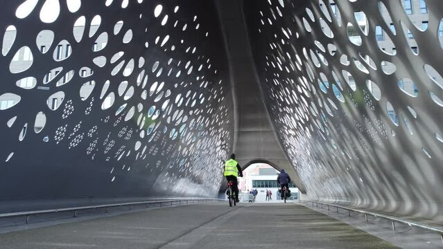 Cyclists and pedestrians walking and pushing pram on bridge in Antwerp