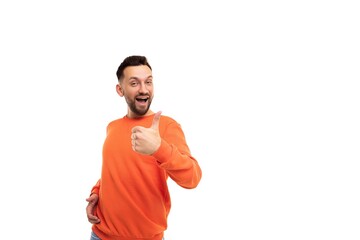 a young charismatic charming man with a beard on a white background in an orange sweater shows a like gesture