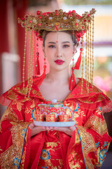 Fototapeta na wymiar Portrait young beautiful Asian woman wear red cheongsam red.