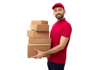 The courier of the delivery service stands in a half-turn and holds in his hands ah uphill...