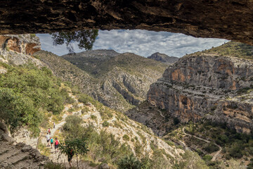 A path through a hole in a wall of rock, in the Route of Six Thousand Steps, at Barranc de l’Infern. The Hell’s Ravine in Vall de Laguar, Alicante, Spain