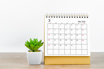 March 2022 desk calendar on wooden background.