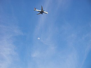 Fototapeta premium 見上げた空に見えた飛行機と月。