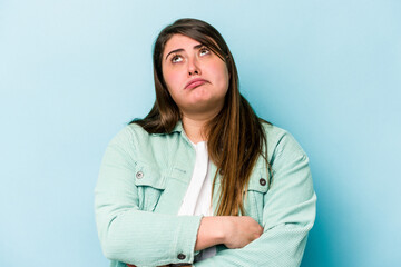 Young caucasian overweight woman isolated on blue background tired of a repetitive task.