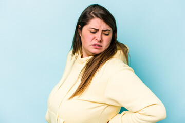 Young caucasian overweight woman isolated on blue background suffering a back pain.