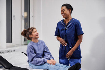 Girl patient and female doctor laughing during appointment