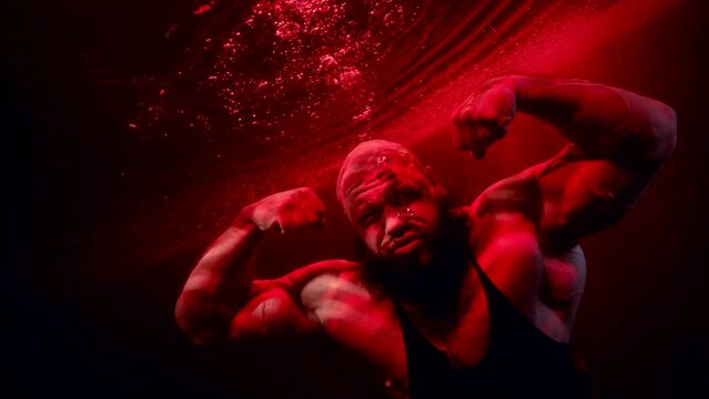 aggressive jock is diving in depth with red blooded water, showing his power and aggression