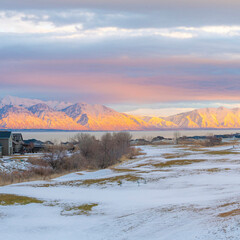 Square Whispy white clouds Snow covered field outside the residential area at Saratoga Springs in...