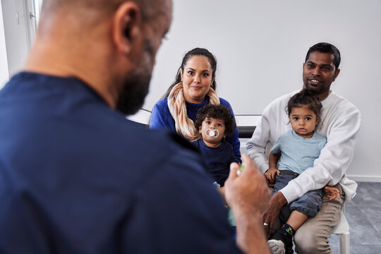 Male doctor talking to family with children