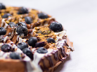 Closeup of belgian waffle with blueberries on white 