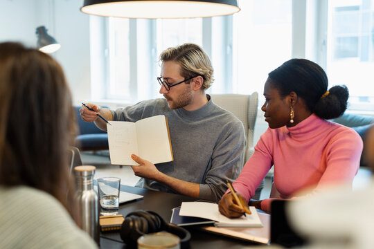 Businessman showing notes during meeting in conference room